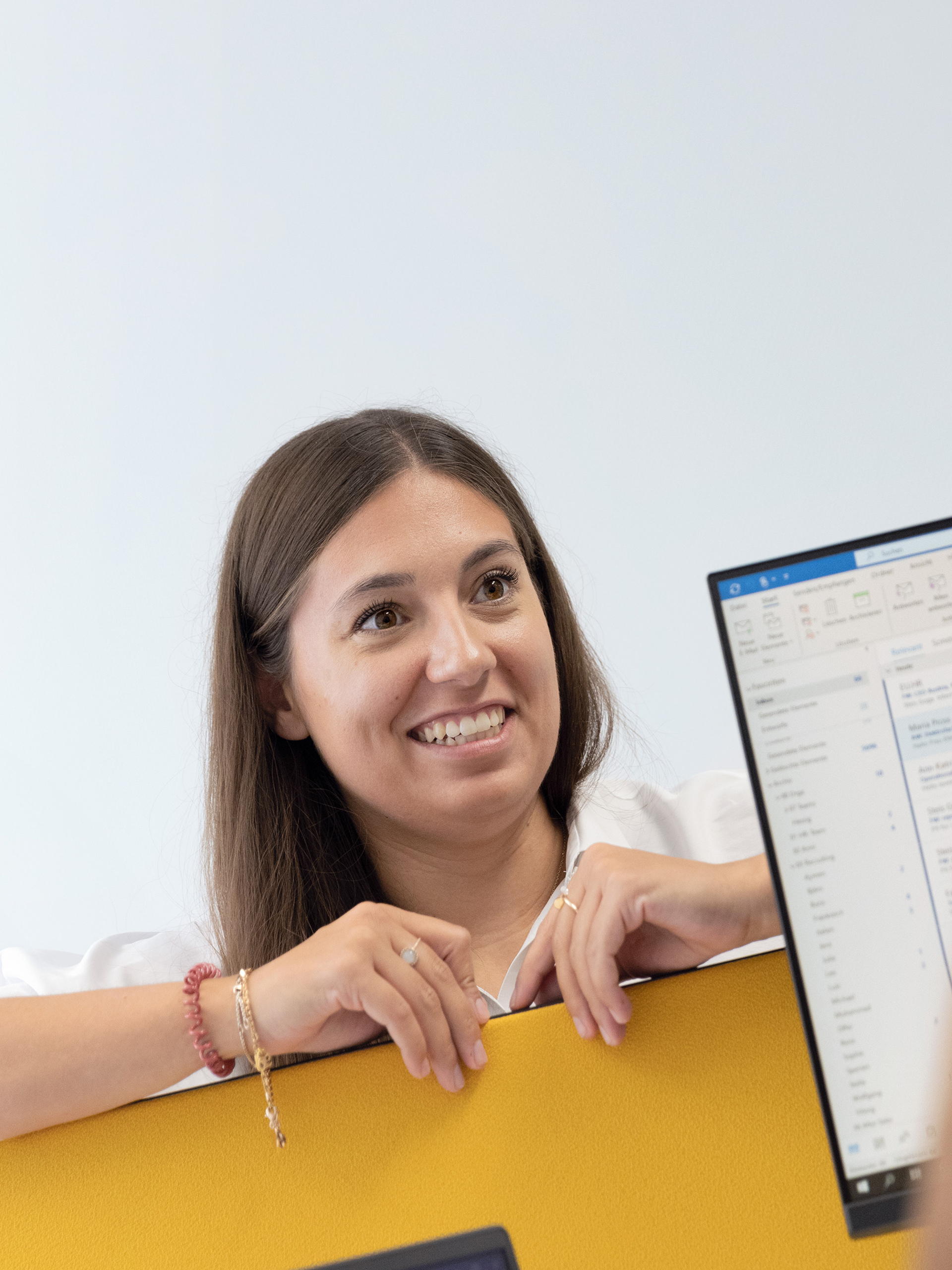 woman leaning over desk smiling